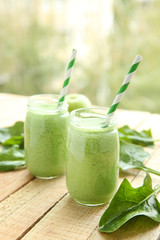 Tasty milk shake cocktails with spinach and apples on wooden table