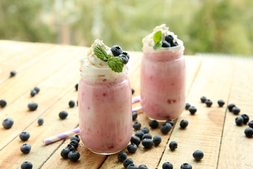 Tasty milk shake cocktails with berries on wooden table