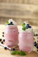 Tasty milk shake cocktails with berries on wooden table