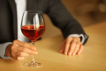 Man holding glass with wine on blurred background
