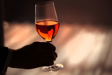 Man holding glass with wine on blurred background