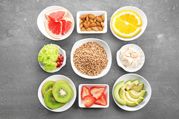 Set of diet products in saucers on grey textured background