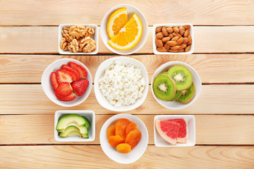 Set of diet products in saucers on wooden background