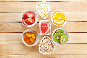 Set of diet products in saucers on wooden background