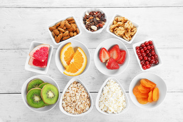 Set of diet products in saucers on wooden background