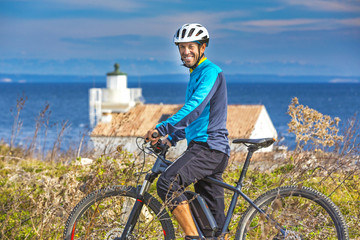 Fototapeta premium Mountainbiker mit Ebike am Meer