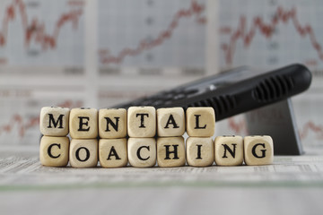 Mental coaching built with letter cube on newspaper background