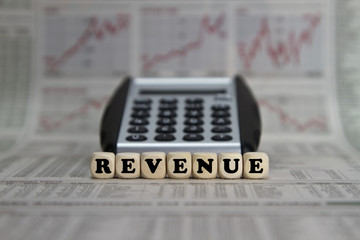 Revenue word with calculator on business newspaper background