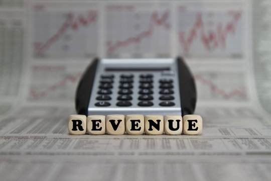 Revenue word with calculator on business newspaper background