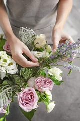 Foto auf Acrylglas Blumenladen Female florist making beautiful bouquet at flower shop