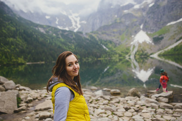 Naklejka premium woman relaxing on the lake and mountains sunny landscape