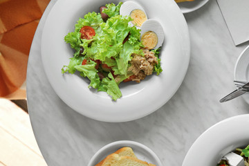 Tasty salad in white plate on table