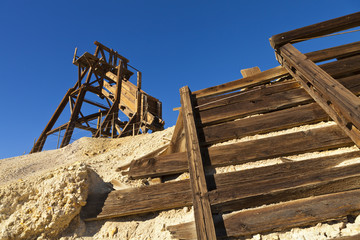 Old wooden mining hopper bin under blue sky in the Nevada Desert near a ghost town.