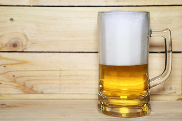 Glass of beer on a piece of wood.