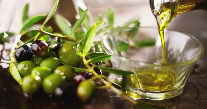 Genuine Italian organic oil cold pressed in slowmotion falls on organic bread. concept of nature and healthy food, healthy and natural. fresh olives and Tuscan Italian oil