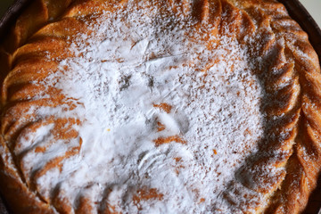 Пирог, посыпанный сверху пудрой, крупным планом