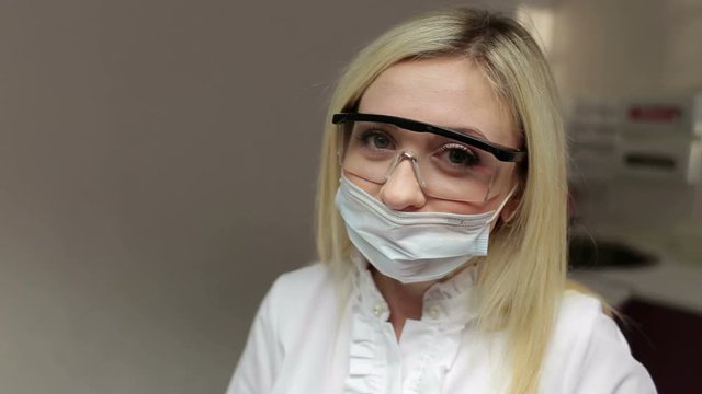 Portrait of young female dentist with protective goggles.
