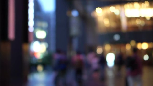 people walking in front of blur shopping mall plaza in evening after work