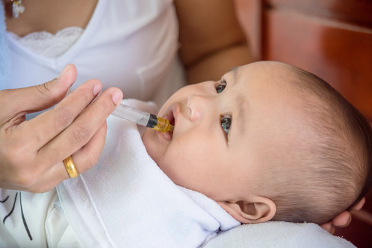 Little Asian Child Eating Medicine Syrup From Syringe