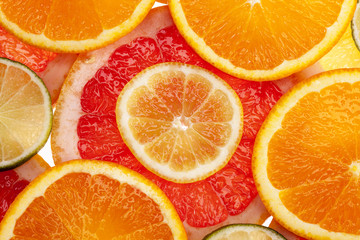 Fototapeta na wymiar Background of different colored slices of citrus fruits ,close up