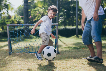 Father and son playing in the park at the day time.