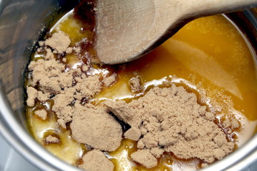 Stirring brown sugar into melted butter in a pan on the hob