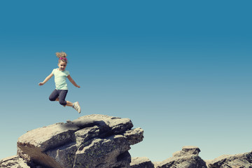 Little girl jumping on stone.
