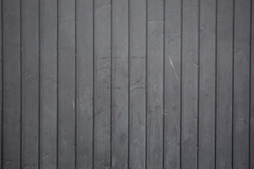 A dark gray background in wooden strips for a modern or urban wallpaper