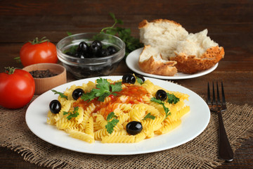 Pasta with sauce and olives on a plate.