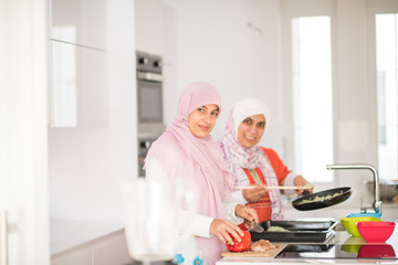 Muslim Arabic traditional woman in kitchen preparing food for lu