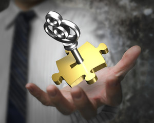 Man hand showing golden puzzle piece with silver key