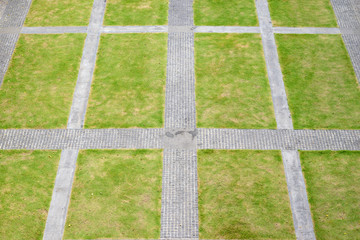 top view of rough stone walkway with green grassy lawn