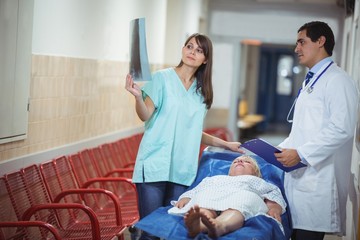 Doctor and nurse examining report in corridor