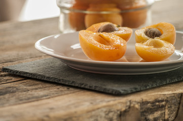 Whole orange apricots with red blush, from above, space for text. Open apricot with stone and leaves. On rustic white wood. - obrazy, fototapety, plakaty