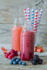 Selection of berry smoothies on rustic wood background