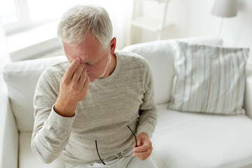 senior man suffering from headache at home