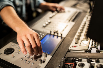 man using mixing console in music recording studio