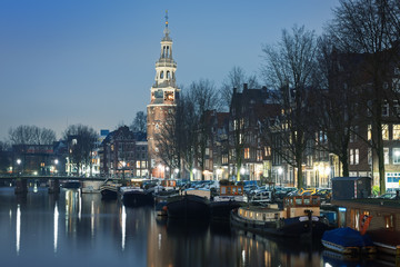 Naklejka premium Embankment in Amsterdam with church in the blue evening light, the Netherlands