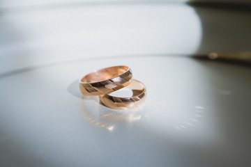 stylish gold wedding rings on a white table