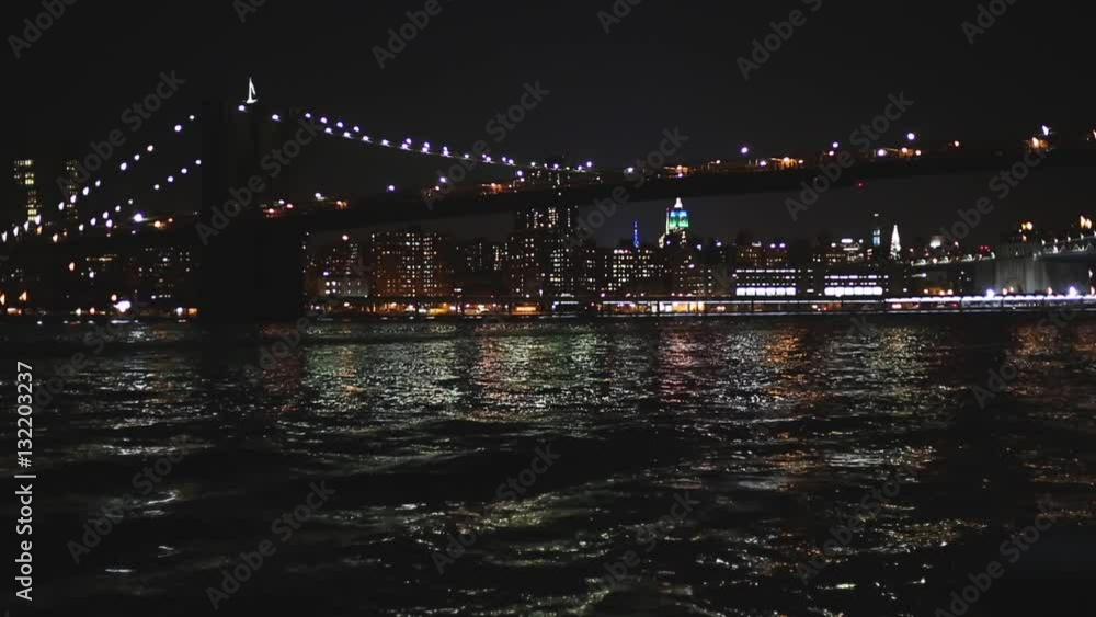 Wall mural brooklyn bridge in new york, night view. lights reflecting on the water and midtown skyscrapers on b