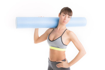 Athletic young woman is holding a foam roller for exercise. Isolated over white.