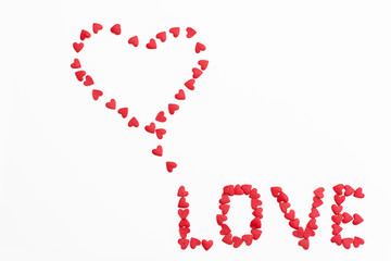 the inscription "love" made of small hearts on a white background. romantic love background