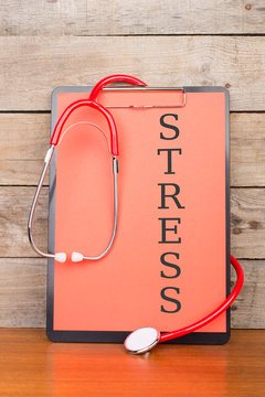 Medical clipboard with text "STRESS" and stethoscope