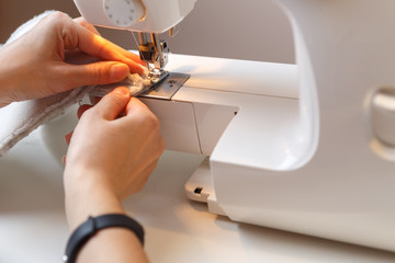 Girl makes stitch on sewing-machine