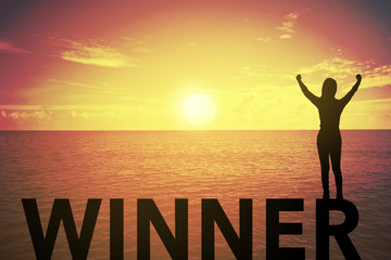 Silhouette young woman standing and raising up hand about winner concept on winner text over a beautiful sunset or sunrise at the sea. background for success.hope to business success