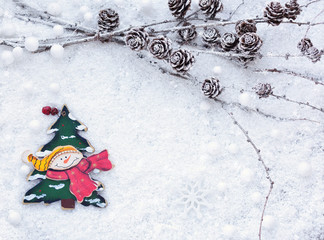 Larch branches with cones and Snowman with decorative Christmas tree on the snow. Christmas background with space for your text.