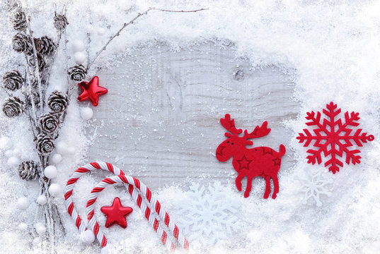 Greeting card with snow and christmas decorations on wooden background. Christmas background with space for your text.