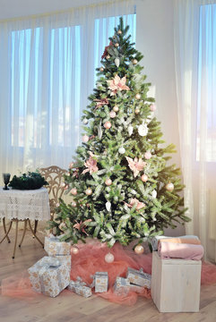 Christmas tree with christmas presents in a room. The concept of Christmas. Christmas sunny morning.