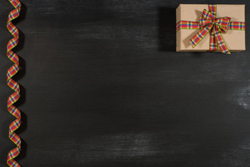 Gift with ribbon on a blackboard.