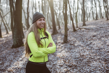 Young runner woman resting in forest after workout